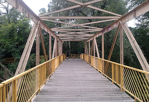 Läufer auf Brücke mit gelbem Geländer