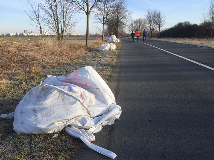 Illegal entsorgter Müll am Straßenrand, weiße Säcke mit OA vom Ordnungsamt markiert