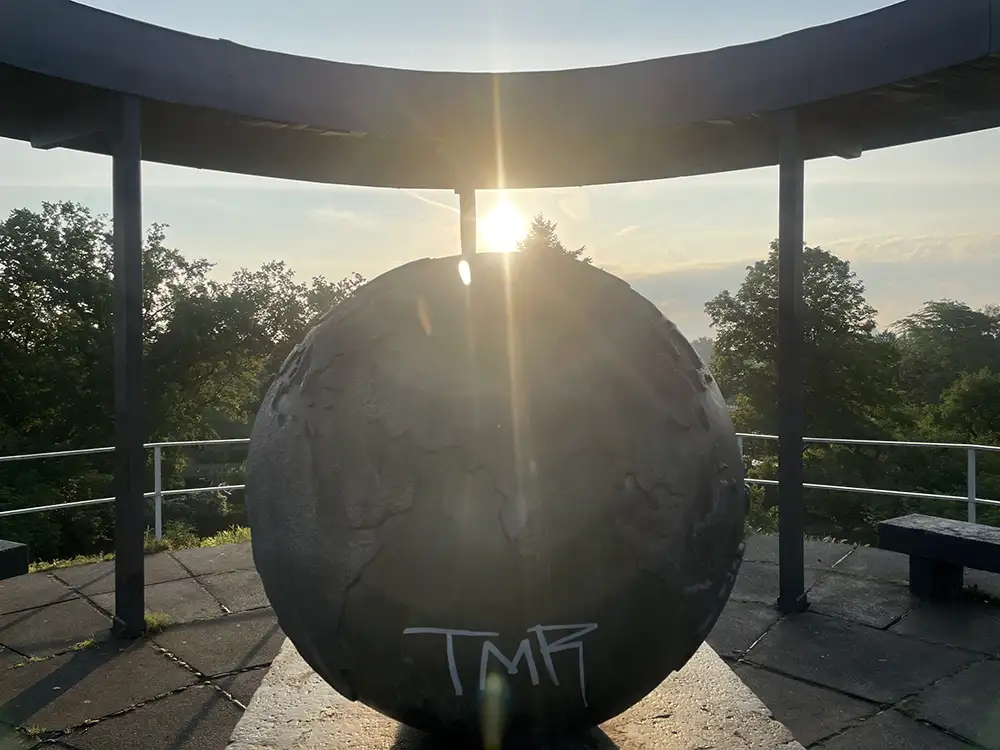 Aufgehende Sonne hinter dem Globus auf dem Lilienthal-Denkmal