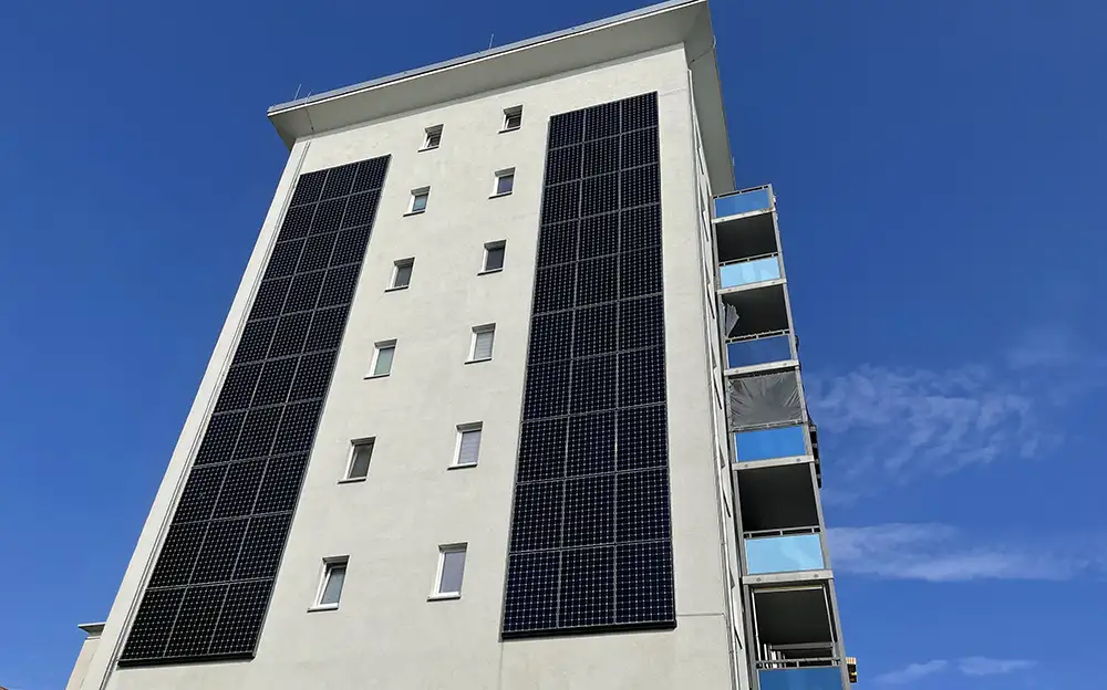 Hohes Wohnhaus mit Solarpaneelen an der Fassade